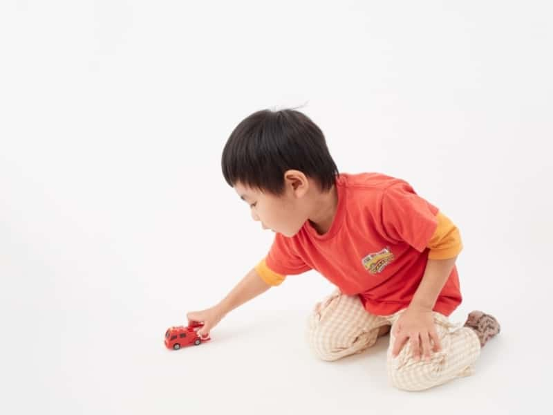 白背景の幼児・ミニカーで遊ぶ